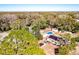 An aerial view features a home with a solar panel roof, pool, shed, and mature trees at 32804 Blossom Ln, Leesburg, FL 34788