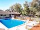 Inviting backyard pool with a charming picket fence, surrounded by lush greenery and comfortable seating at 32804 Blossom Ln, Leesburg, FL 34788