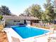 Inviting backyard pool with a charming picket fence, surrounded by lush greenery and comfortable seating at 32804 Blossom Ln, Leesburg, FL 34788