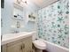 Charming bathroom with a patterned shower curtain, a vanity sink, and a wall-mounted shelf at 32804 Blossom Ln, Leesburg, FL 34788