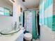 Charming bathroom with a glass vessel sink, blue accent tiles, and a stylish shower curtain at 32804 Blossom Ln, Leesburg, FL 34788
