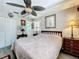 A welcoming bedroom with a cozy bed, a ceiling fan, and a classic wooden dresser at 32804 Blossom Ln, Leesburg, FL 34788