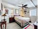 Inviting bedroom featuring a comfortable bed with a patterned comforter, a ceiling fan, and two dressers at 32804 Blossom Ln, Leesburg, FL 34788