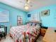 Bright bedroom featuring a comfy bed with a quilt and pastel colored walls, complemented by a ceiling fan at 32804 Blossom Ln, Leesburg, FL 34788