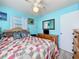 Inviting bedroom with a cozy quilt bed, a ceiling fan, and a dresser against a soft blue wall at 32804 Blossom Ln, Leesburg, FL 34788