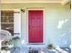 Close up of the bright red front door featuring stylish white shutters and matching decor at 32804 Blossom Ln, Leesburg, FL 34788