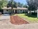Charming single-story home with a well-maintained front yard, mature landscaping, and a cozy bench by the front door at 32804 Blossom Ln, Leesburg, FL 34788