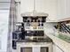 Bright kitchen with stainless steel stove and hood, white cabinets, and decorative backsplash at 32804 Blossom Ln, Leesburg, FL 34788
