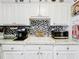 Charming kitchen featuring white cabinetry, mosaic backsplash, and modern stainless steel appliances at 32804 Blossom Ln, Leesburg, FL 34788