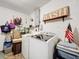 Well-lit laundry room featuring a modern washer and dryer, accompanied by storage options and wall decor at 32804 Blossom Ln, Leesburg, FL 34788