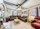 Spacious living room with tile flooring, ceiling fan, and comfortable leather sofas at 32804 Blossom Ln, Leesburg, FL 34788