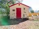 A decorated shed with a red door adds a touch of character to the backyard at 32804 Blossom Ln, Leesburg, FL 34788