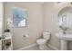 Half bathroom featuring decorative mirror, pedestal sink, and natural light from a window at 365 Quarry Rock Cir, Kissimmee, FL 34758