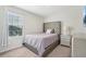 Comfortable bedroom with tufted headboard, window, and neutral color scheme at 365 Quarry Rock Cir, Kissimmee, FL 34758