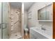 Bathroom features a tiled shower with built-in shelves, a toilet, a sink and wood-look flooring at 38934 Sulen Rd, Lady Lake, FL 32159