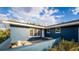 Blue exterior showcasing the home's facade, including windows and well-maintained landscaping at 38934 Sulen Rd, Lady Lake, FL 32159