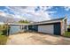 A single-story home has light blue siding with a brick accent and large driveway at 38934 Sulen Rd, Lady Lake, FL 32159