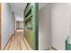 Hallway with wood floors, neutral walls, a green bookshelf, and stairs going down at 38934 Sulen Rd, Lady Lake, FL 32159