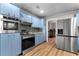 Well-lit kitchen featuring light blue cabinets, stainless steel appliances, granite countertops, and wood flooring at 38934 Sulen Rd, Lady Lake, FL 32159
