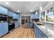 Charming kitchen featuring light blue cabinets, stainless steel appliances, granite countertops, and wood flooring at 38934 Sulen Rd, Lady Lake, FL 32159