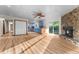 Bright living room featuring a stone fireplace, sliding glass doors, wood floors, and kitchen views at 38934 Sulen Rd, Lady Lake, FL 32159