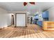 Open-concept living room with wood flooring, leading to a kitchen with blue cabinets, and a fireplace at 38934 Sulen Rd, Lady Lake, FL 32159