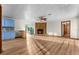 Spacious living room with wood floors, fireplace, and a partial view of the kitchen featuring blue cabinetry at 38934 Sulen Rd, Lady Lake, FL 32159