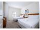 Cozy bedroom with two beds, dresser, carpet, and a window provides natural light at 5354 Diplomat Ct # 106, Kissimmee, FL 34746