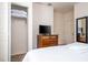 Comfortable bedroom with a flat-screen TV, dresser, and an open closet showcasing linens and storage at 5354 Diplomat Ct # 106, Kissimmee, FL 34746
