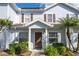Light blue townhouse with a covered entryway, landscaped garden beds, and dark shutters at 5354 Diplomat Ct # 106, Kissimmee, FL 34746