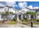 Light blue townhouse featuring manicured landscaping, a covered entryway, and brown shutters at 5354 Diplomat Ct # 106, Kissimmee, FL 34746