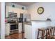 Cozy kitchen featuring stainless steel appliances, light wood cabinets, and a breakfast bar with wooden stools at 5354 Diplomat Ct # 106, Kissimmee, FL 34746
