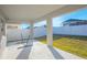 Covered back porch with a bright white ceiling and posts facing the backyard and fence at 5430 Pine Lilly Dr, St Cloud, FL 34771