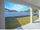 View from covered back porch towards the lawn, white fence, and neighboring property at 5430 Pine Lilly Dr, St Cloud, FL 34771
