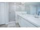 Bathroom featuring double sinks, white cabinets, a large glass shower, and gray wood-look floors at 5430 Pine Lilly Dr, St Cloud, FL 34771