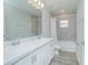 Bright bathroom with double sinks, white cabinets, shower and tub with tile surround at 5430 Pine Lilly Dr, St Cloud, FL 34771
