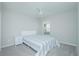 Bedroom with gray carpeting, ceiling fan, one window, and a bed with a light-colored striped comforter at 5430 Pine Lilly Dr, St Cloud, FL 34771
