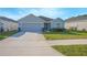 Charming single-story home with a well-maintained lawn and gray exterior paint at 5430 Pine Lilly Dr, St Cloud, FL 34771