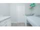 Laundry room features white appliances and cabinets, gray countertop, and gray wood-look flooring at 5430 Pine Lilly Dr, St Cloud, FL 34771