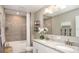 Bathroom featuring double sinks with granite countertops, a shower-tub combo, and neutral decor at 5563 Maddie Dr, Haines City, FL 33844