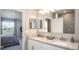 Bathroom featuring double sinks, a granite countertop, and a combined shower-tub with grey tiling at 5563 Maddie Dr, Haines City, FL 33844