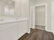 Bathroom vanity featuring double sinks, white cabinets, and wood-look flooring, with closet view at 5844 Galloping Dr, Apopka, FL 32712