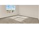 Bedroom featuring a window with backyard views, neutral walls, and carpet flooring at 5844 Galloping Dr, Apopka, FL 32712
