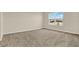 Bright empty bedroom showcases neutral walls, plush carpet, and a large window view at 5844 Galloping Dr, Apopka, FL 32712