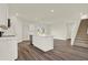 Bright kitchen featuring a large island with sink, stainless steel appliances, and an adjacent staircase at 5844 Galloping Dr, Apopka, FL 32712