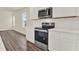 Modern kitchen with stainless steel appliances, white cabinets, and white subway tile backsplash at 5844 Galloping Dr, Apopka, FL 32712