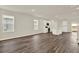 Open-concept living space features modern kitchen with white cabinets and wood-look flooring throughout at 5844 Galloping Dr, Apopka, FL 32712