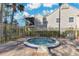 Community hot tub area surrounded by a security fence, landscaping, and lounge chairs at 615 Richland Ct # 61, Altamonte Springs, FL 32714
