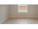 An empty bedroom with neutral paint color and tile floors at 6598 Lullaby Way, Mascotte, FL 34753