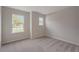 Cozy bedroom features soft carpeting, two bright windows, and a neutral color palette for a tranquil atmosphere at 6598 Lullaby Way, Mascotte, FL 34753